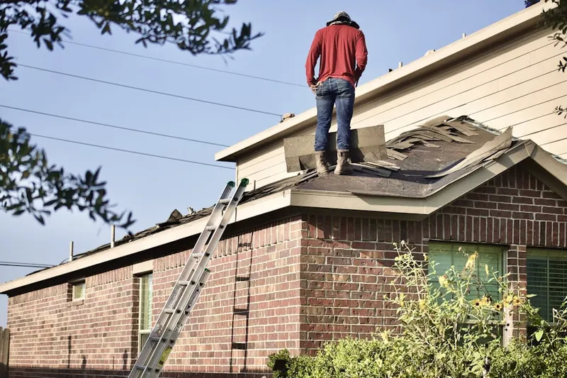 Professional roofer working on a residential roof in Vergennes